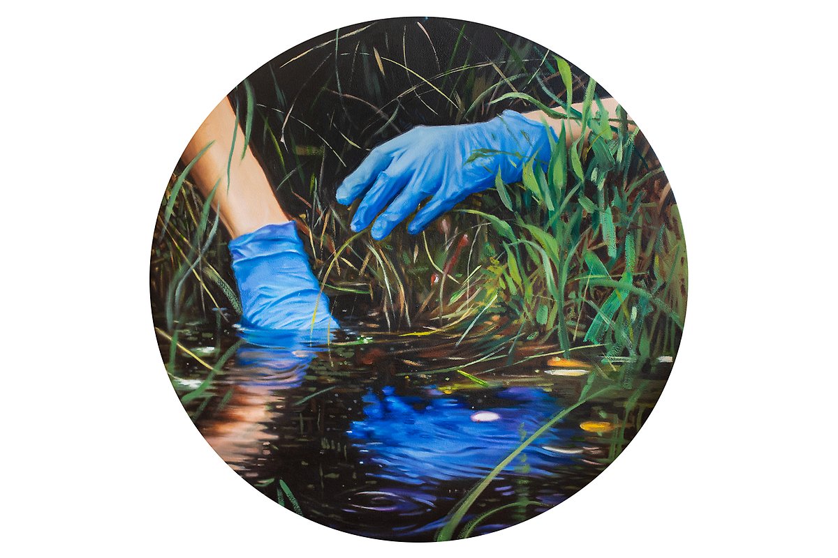 En rund målning med två händer i blåa plasthandskar sträcker sig ner mot mörkt vatten omgivet av grönt gräs.